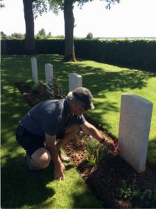 David places flag with poppy at Alex Novinka's grave